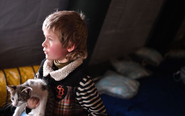 Dete izbeglica iz Marijupolja sa mačetom na punktu prve pomoći za evakuisano stanovništvo, koji je organizovalo Ministarstvo za vanredne situacije DNR u Novoazovskom rejonu.  - Sputnik Srbija