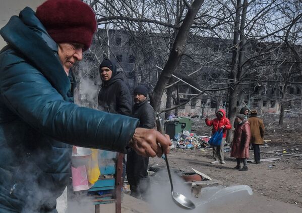 Ljudi na periferiji Marijupolja pripremaju hranu u dvorištu. U gradu nema vode.Sukobi jedinica Oružanih snaga Rusije i Narodne milicije DNR protiv ukrajinskih nacionalista se nastavljaju u centru grada. - Sputnik Srbija