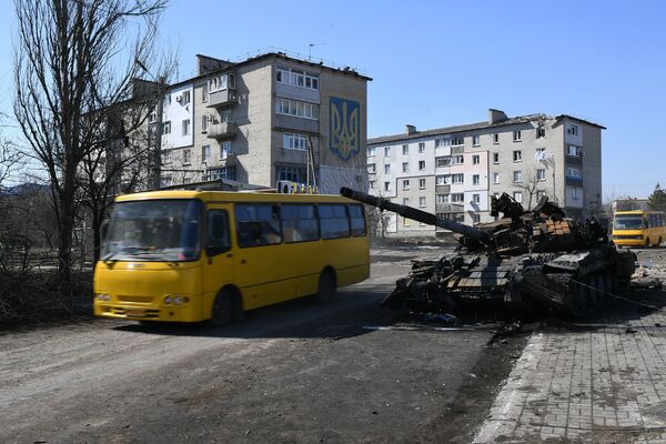 Уништени тенк Оружаних снага Украјине поред гранатираних зграда у Волновахи.  - Sputnik Србија