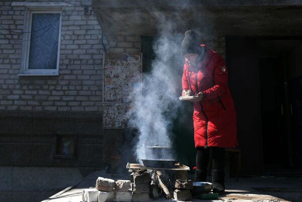 Жене припремају храну на огњишту у дворишту куће у Волновахи. - Sputnik Србија