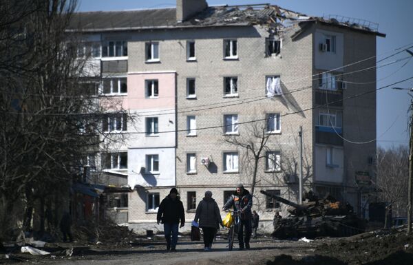 Uništeni tenk Oružanih snaga Ukrajine oko granatirane zgrade u Volnovahi. - Sputnik Srbija