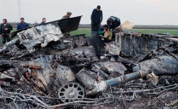 Jedinice Jugoslovenske protiv-vazdušne odbrane oborili su stelt bombarder F-117, koji se srušio blizu sela Buđanovci kod Rume. Tog dana je NATO takođe koristio zabranjene kasetne bombe.Na fotografiji: Stručnjaci Vojske Jugoslavije proveravaju olupinu oborenog „nevidljivog“ F-117 aviona u selu Buđanovci, nedelja 28. mart 1999. Pilota je u dobrom stanju spasila borbena spasilačka ekipa, a američki zvaničnici rekli su da ne znaju uzrok nesreće. - Sputnik Srbija