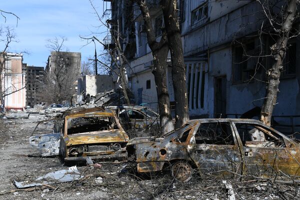 Zapaljeni automobili i uništene kuće u Marijupolju kao posledica granatiranja. - Sputnik Srbija