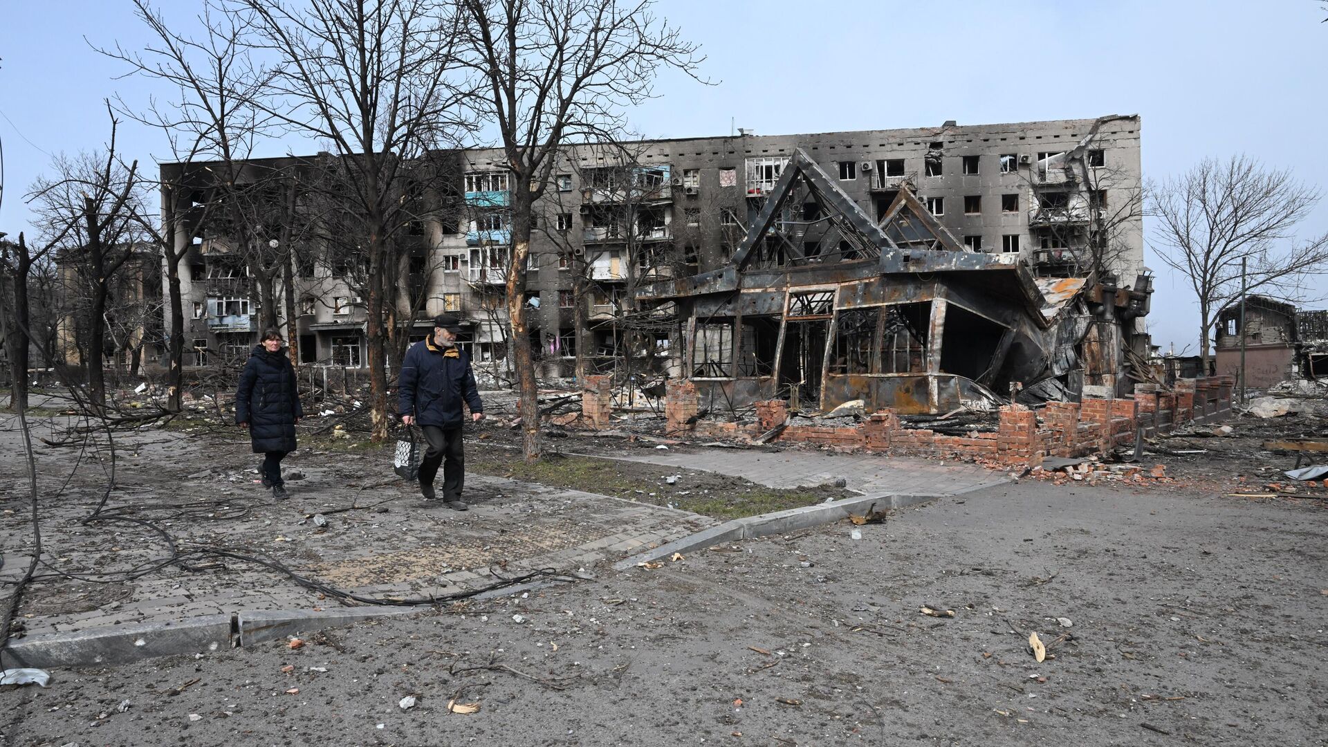 Жители города проходят мимо разрушенных жилых домов в Мариуполе - Sputnik Србија, 1920, 06.06.2022