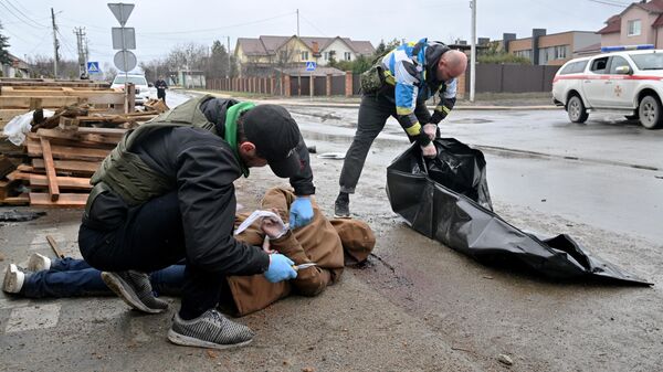 Komunalni radnici sklanjaju leševe ljudi koje je navodno ubila ruska vojska u ukrajinskoj Buči - Sputnik Srbija