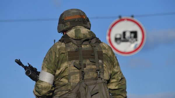 Военнослужащий НМ ДНР во время ожидания раненых украинских военных у входа на завод Азовсталь в Мариуполе - Sputnik Србија