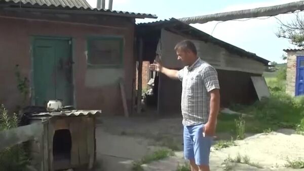 Meštanin pokazuje kako mu je deo ukrajinske kasetne bombe pogodio kuću - Sputnik Srbija