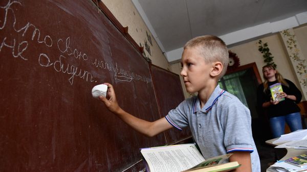 Učenik pišet melom na doske na zanяtiяh v škole № 65 Mariupolя - Sputnik Srbija
