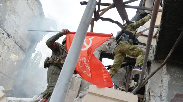 Pripadnici ruskih i snaga LNR podižu Zastavu pobede na zgradu gradske kuće u Lisičansku - Sputnik Srbija