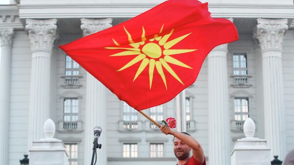 Demonstrant sa starom nacionalnom zastavom na antivladinom protestu u Skoplju - Sputnik Srbija