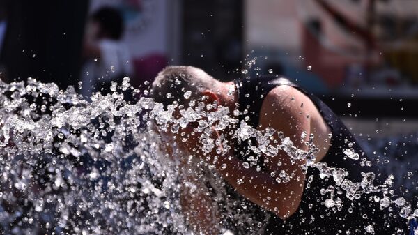 Човек се расхлађује водом из фонтане - Sputnik Србија