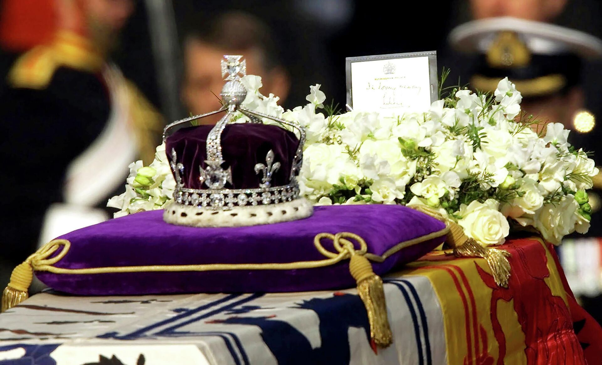 The Koh-i-noor, or mountain of light, diamond, set in the Maltese Cross at the front of the crown made for Britain's late Queen Mother Elizabeth, is seen on her coffin, along with her personal standard, a wreath and a note from her daughter, Queen Elizabeth II, as it is drawn to London's Westminster Hall, April 5, 2002. - Sputnik Srbija, 1920, 13.09.2022