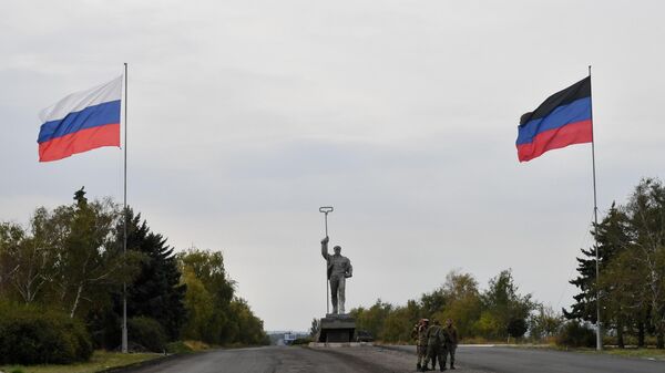 Заставе Русије и Донбаса испред скулптуре Стаљевар на уласку у Маријупољ - Sputnik Србија
