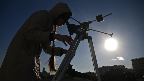 Devuška nablюdaet v teleskop častičnoe solnečnoe zatmenie v Moskve - Sputnik Srbija