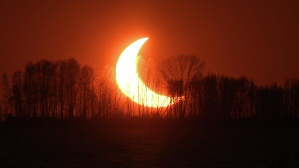 Delimično pomračenje Sunca uočeno na zalasku u blizini Novosibirska. - Sputnik Srbija