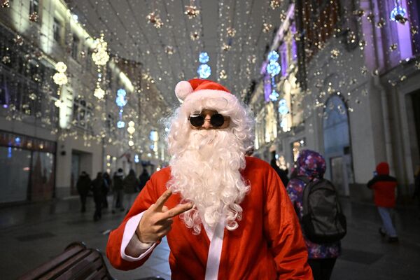 Čovek obučen u Deda Mraza tokom novogodišnje noći u Nikoljskoj ulici u Moskvi. - Sputnik Srbija