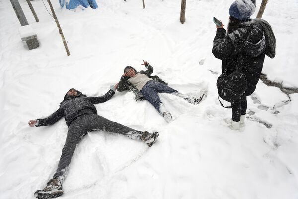 Људи уживају правећи анђеле у снегу у северном делу Техерана. - Sputnik Србија