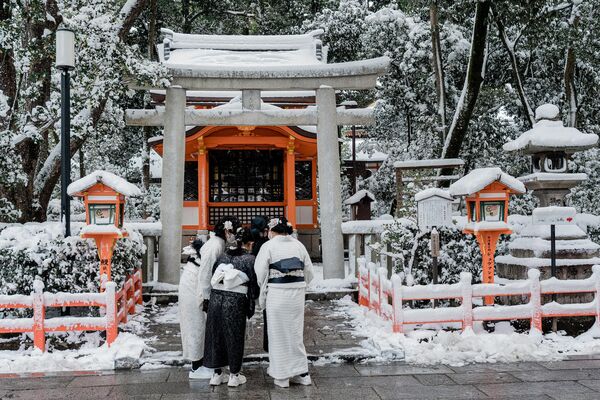 Japanci u tradicionalnoj odeći posećuju hram Jasaka u Kjotu, nakon što je cele noći padao sneg. (Photo by Fred Mery / AFP) - Sputnik Srbija