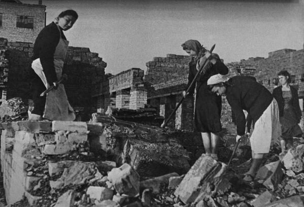 Обнављање Стаљинграда неколико месеци након завршетка (у фебруару 1943. г.) Стаљинградске битке. Жене раде на улицама уништеног града, склањајући рушевине стамбених објеката. - Sputnik Србија