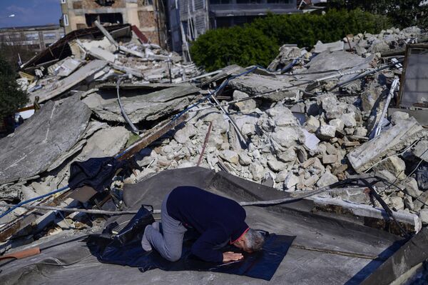 Muškarac se moli na uništenom mestu Velike džamije u Hataju, 11. februara 2023. godine. - Sputnik Srbija