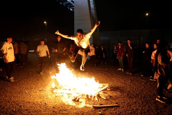 Iranac preskače vatru tokom festivala vatre Čaharašanbe surim poznatog i kao Skreletna sreda, koji se održava poslednje srede pred praznik Novruz, poznat i kao Iranska Nova godina - Sputnik Srbija