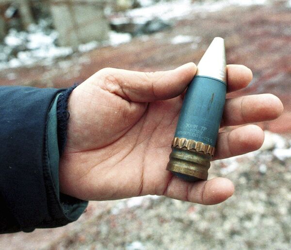 Član tima za ispitivanje radijacije drži oklopnu granatu kalibra 30 milimetara sa osiromašenim uranijumom, koju je NATO koristio tokom vazdušnih napada na položaje Vojske Republike Srpske 1995. godine. Granata pronađena u bivšoj vojnoj fabrici u predgrađu Vogošća kod Sarajeva, 15. januar 2001.. - Sputnik Srbija