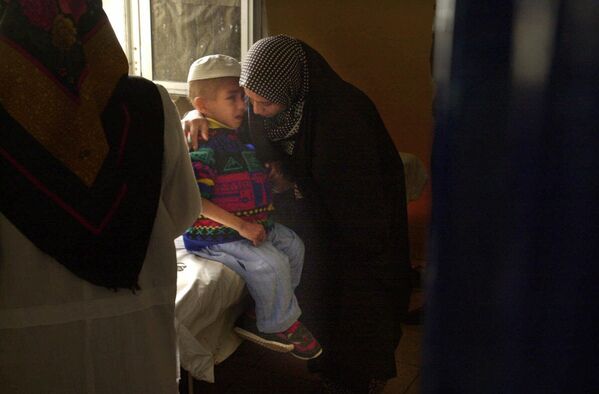 Osmogodišnjeg Ahmeda Radija teši njegova majka Telba Ramadan dok čeka nedeljni tretman hemoterapije u dečjoj bolnici u Basri, u Iraku 15. januara 2001. Radi je među sve većim brojem obolelih od raka, a iračka vlada tvrdi da je uzrok tome osiromašeni uranijum koji su tokom Zalivskog rata koristile savezničke snage predvođene SAD. - Sputnik Srbija