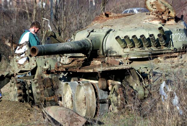 Etnički Albanac prolazi pored tenka Vojske Jugoslavije uništenog tokom NATO bombardovanja u gradu Klini na zapadu Kosova, u petak, 5. januara 2001.  - Sputnik Srbija