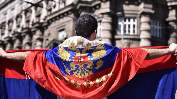 Мушкарац огрнут заставом Русије испред зграде Владе Србије - Sputnik Србија
