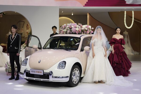 Манекени у одећи за венчања испред електричног аутомобила „ора фанки кат“ кинеске компаније „Грејт вол“ - Sputnik Србија