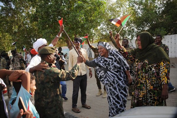 Ljudi pozdravljaju Osmana Mohameda, generala lojalnog komandantu vojske Abdelu Fatahu al-Burhanu. General al-Burhan se oslanja na vojsku, obaveštajne službe i policiju, a takođe direktno nadgleda sudanski vojno-industrijski kompleks. - Sputnik Srbija