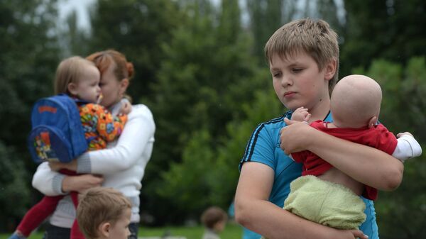 Беженцы с детьми из города Славянск перед отправкой на авобусах из пригорода Донецка на территорию России - Sputnik Србија