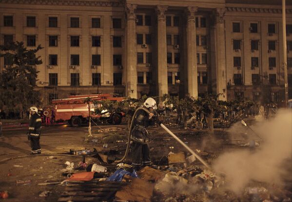 Ватрогасац гаси пожар испред запаљене зграде Дома синдиката у којој је више од 40 људи погинуло. - Sputnik Србија