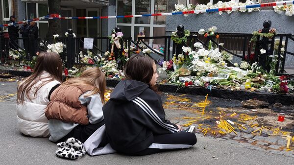 Tri devojčice sede na ulici ispred škole Vladislav Ribnikar na Vračaru” nakon masovne pucnjave 3. maja 2023. - Sputnik Srbija