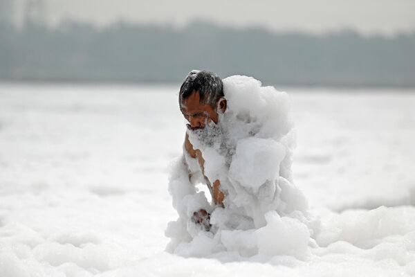 На фотографији човек се купа у загађеној води реке Јамуна у Њу Делхију уочи Светског дана заштите животне средине. - Sputnik Србија