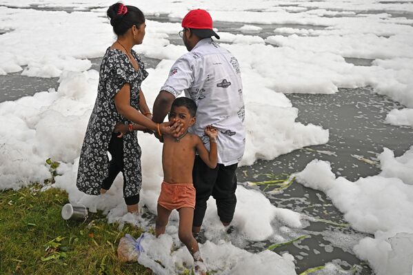 Porodica se kupa u zagađenoj vodi reke Jamuna punoj pene. - Sputnik Srbija