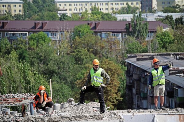 Радници приликом демонтаже последњих спратова оштећене куће на Авенији Лењин у Маријупољу. - Sputnik Србија