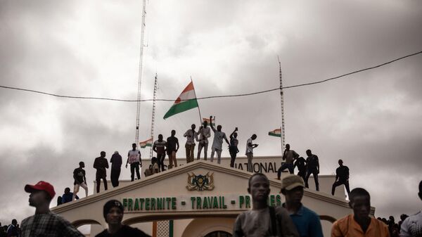 Protesters hold a Niger flag during a demonstration on independence day in Niamey on August 3, 2023. Hundreds of people backing the coup in Niger gathered on August 3, 2023 for a mass rally in the capital Niamey with some brandishing giant Russian flags. - Sputnik Srbija
