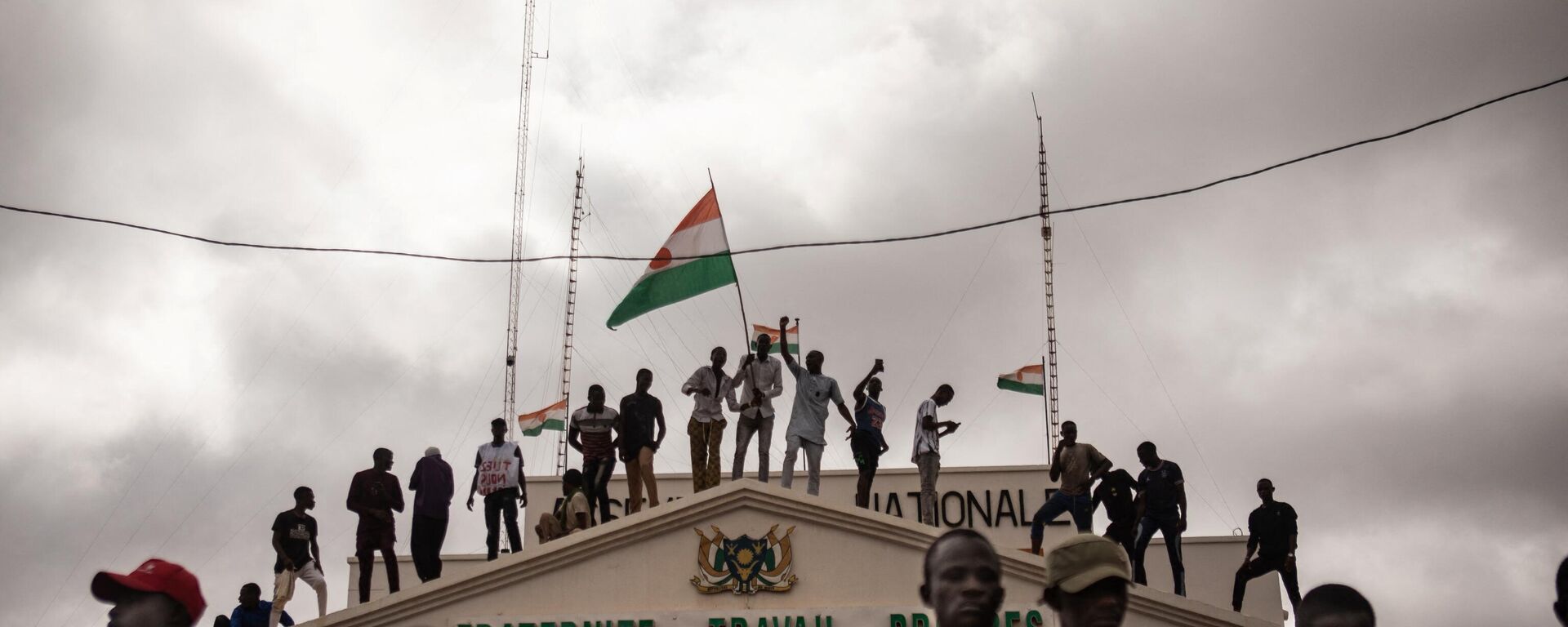 Protesters hold a Niger flag during a demonstration on independence day in Niamey on August 3, 2023. Hundreds of people backing the coup in Niger gathered on August 3, 2023 for a mass rally in the capital Niamey with some brandishing giant Russian flags. - Sputnik Србија, 1920, 25.08.2023