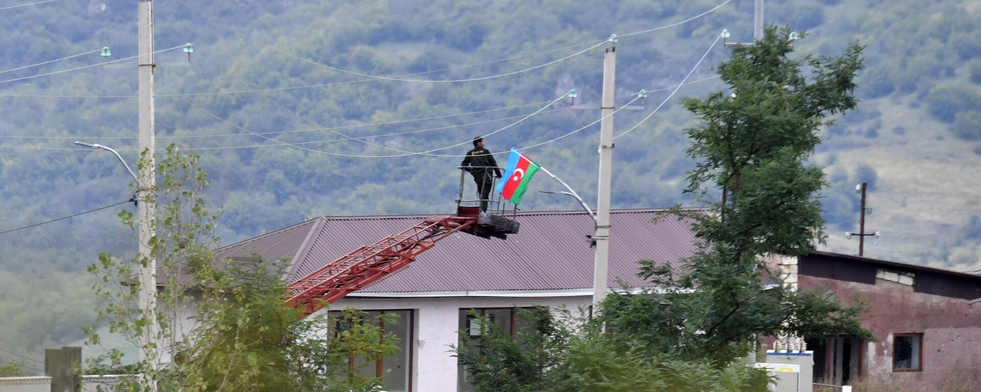 Radnik postavlja zastavu Azerbejdžana na jedno od naselja u Nagorno Karabahu - Sputnik Srbija, 1920, 24.09.2023
