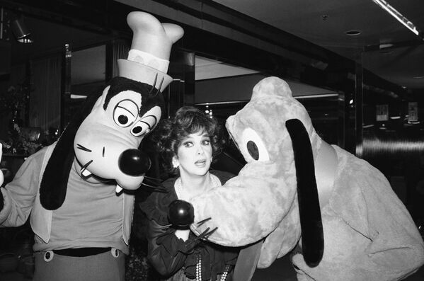 Glumica Đina Lolobriđida sa likovima Volta Diznija Šiljomi Plutonom na zabavi povodom proslave Diznijevog 20. dugometražnog animiranog igranog filma „Lisica i pas“ održanoj u Blumingdejlu, 1981. godine. - Sputnik Srbija