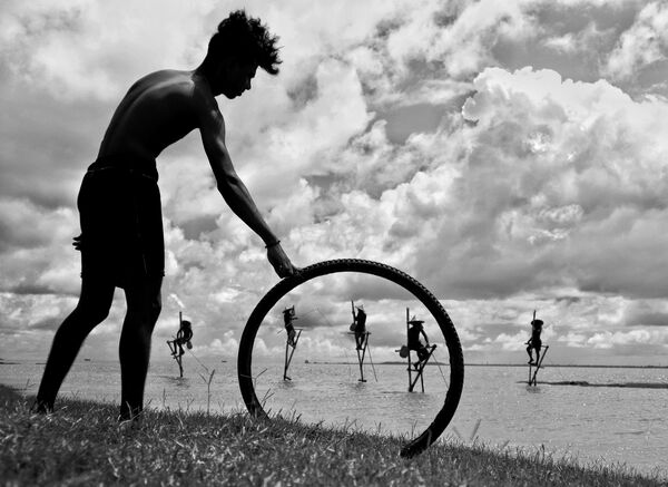 Саиан Адхикари из Индије освојио је прво место својом фотографијом &quot;Умирућа традиција. Поглед кроз круг&quot; у категорији &quot;Моја планета, појединачна фотографија&quot;. - Sputnik Србија