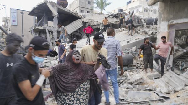 Palestinci na ruševinama zgrade uništene u bombardovanju u Pojasu Gaze - Sputnik Srbija