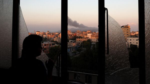 Палестинский ребенок наблюдает, как поднимается дым после израильского авиаудара по городу Газа - Sputnik Србија