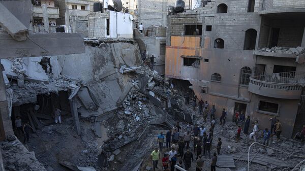 Палестинцы ищут выживших в здании, разрушенном в результате израильской бомбардировки в Хан-Юнисе, сектор Газа - Sputnik Србија