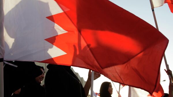Bahrainis wave national flags during a protest march against the government in Sitra, Bahrain, Friday, Sept. 12, 2014. A few thousand protesters chanted for democracy in the Gulf island kingdom and freedom for people jailed during the 3 1/2-year-old uprising. (AP Photo/Hasan Jamali) - Sputnik Србија