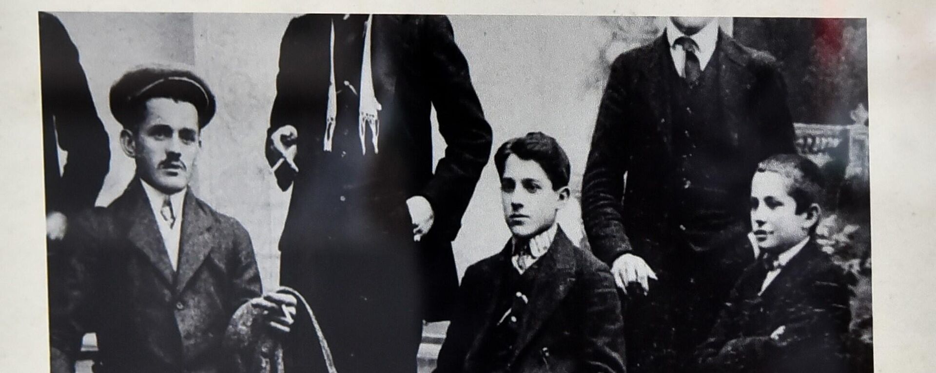 Фотографија Гаврила Принципа са књигом у рукама из 1910. године, на којој Принцип седи, окружен са своја два брата и неколико непознатих особа   - Sputnik Србија, 1920, 10.11.2023