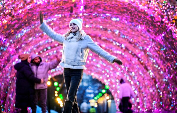 Жена шета испред новогодишњих украса у центру Москве. - Sputnik Србија