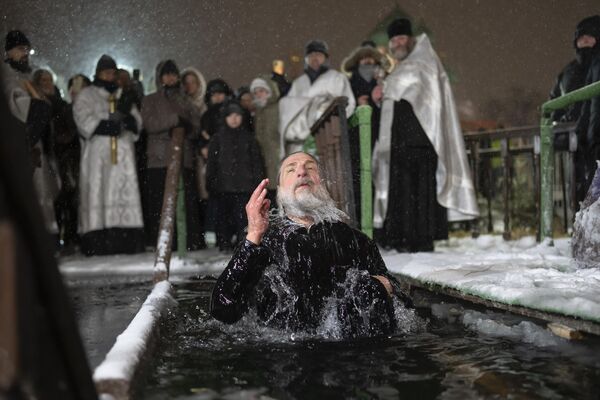 Ruski sveštenik se krsti dok se kupa u ledenoj vodi na Bogojavljenje u Moskvi. - Sputnik Srbija