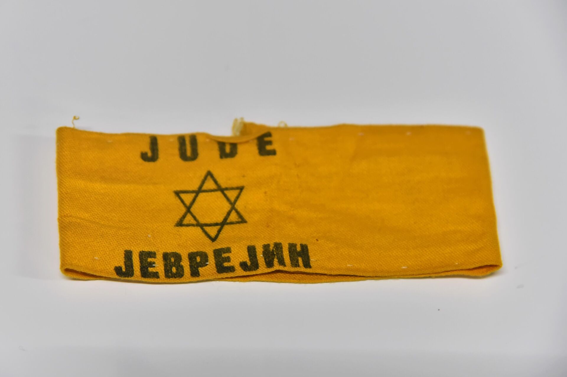 Žuta traka sa natpisom Jude – Jevrejin i Davidovom zvezdom koje su Jevreji morali nositi u okupiranom Beogradu - Sputnik Srbija, 1920, 26.01.2024